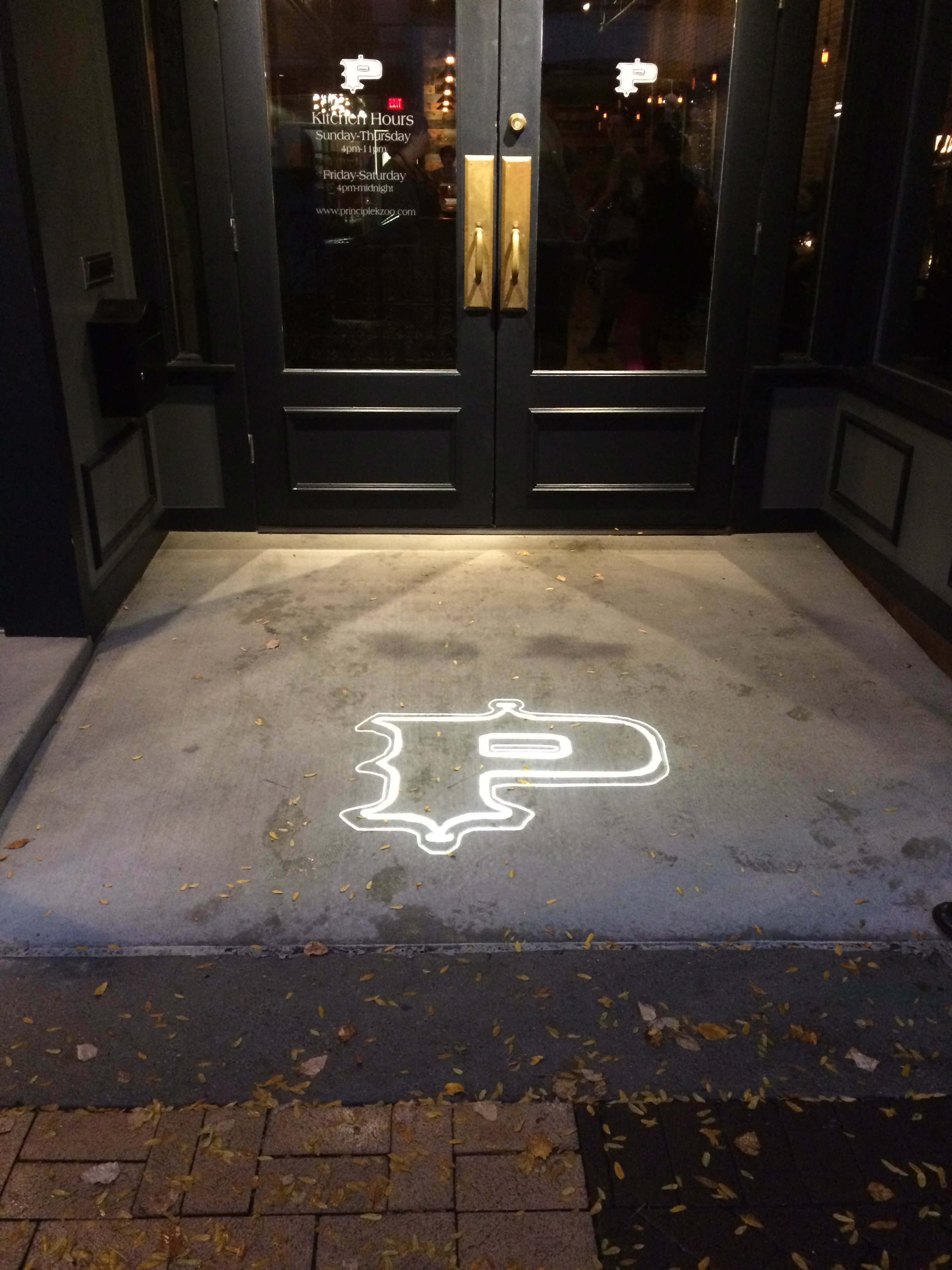 The entrance to the restaurant; there is a fancy letter P shining on the ground