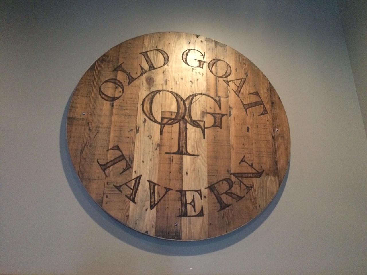 A vintage wooden sign that says 'Old Goat Tavern'