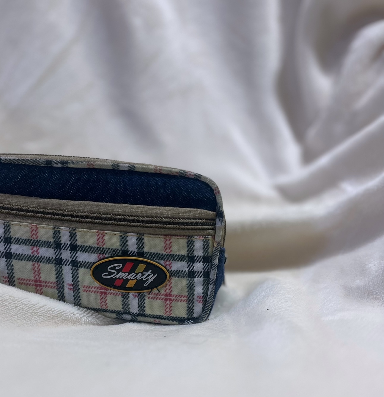 Picture of a blue and cream colored Smarty pencil case on a white background.