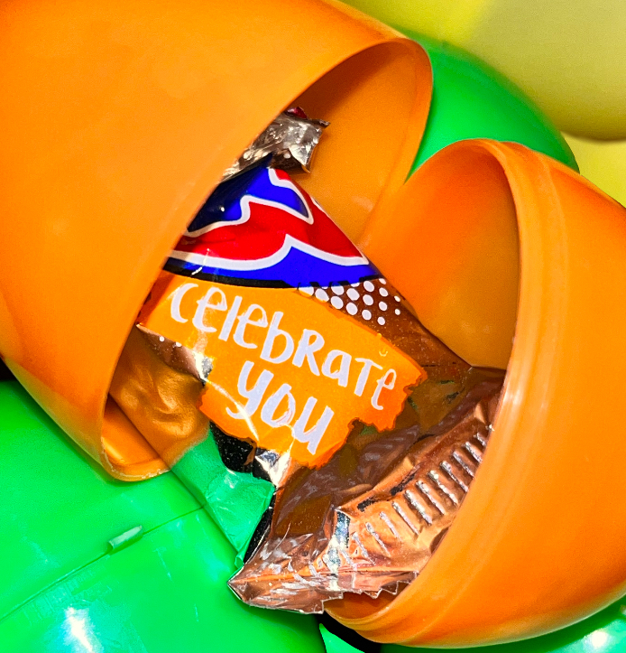 Colorful easter eggs with the center one opened to reveal a 3-Musketeers candy square that has the words 'Celebrate You'.